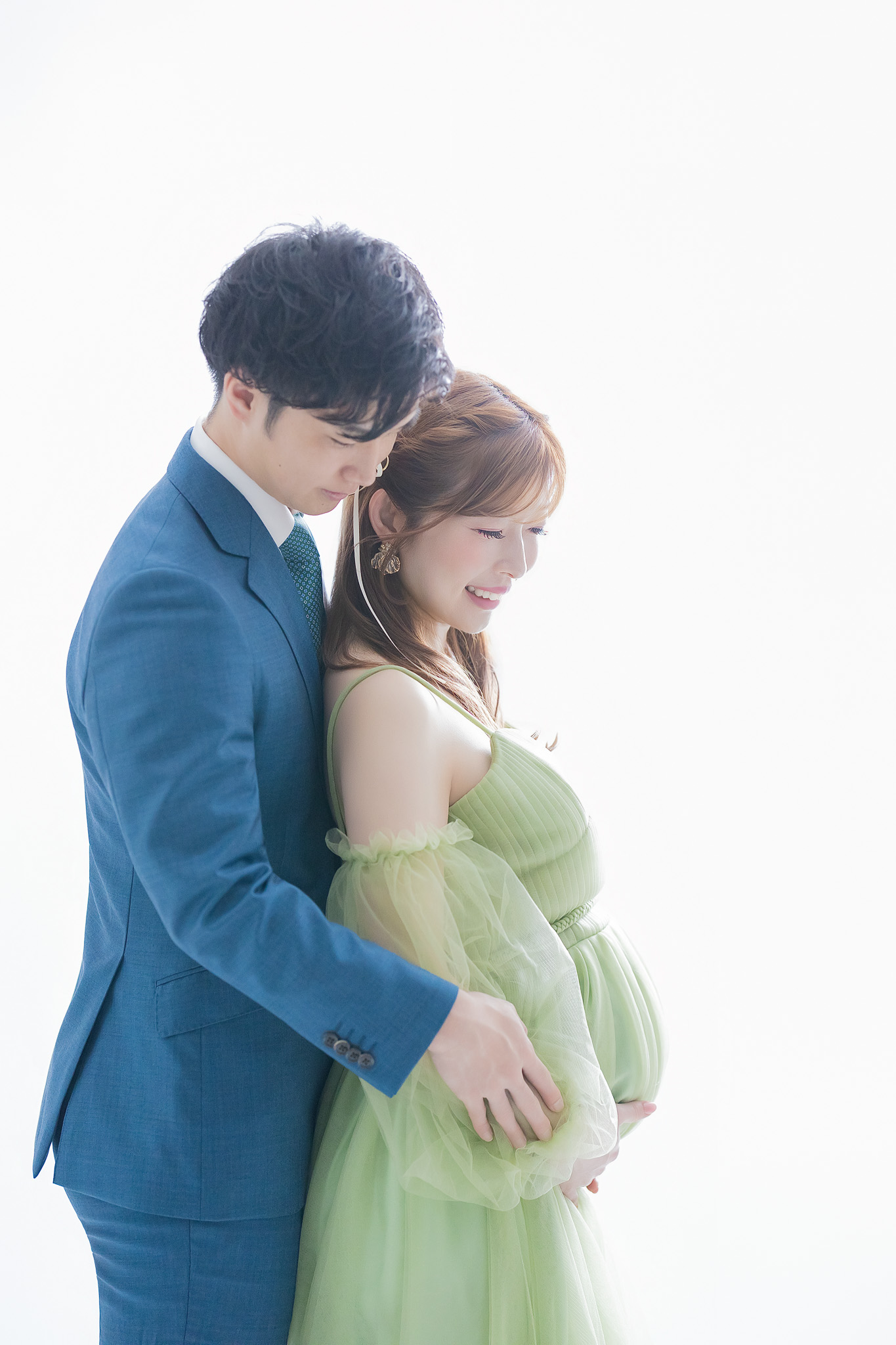 後ろから寄り添い、ともにお腹を見つめるご夫婦