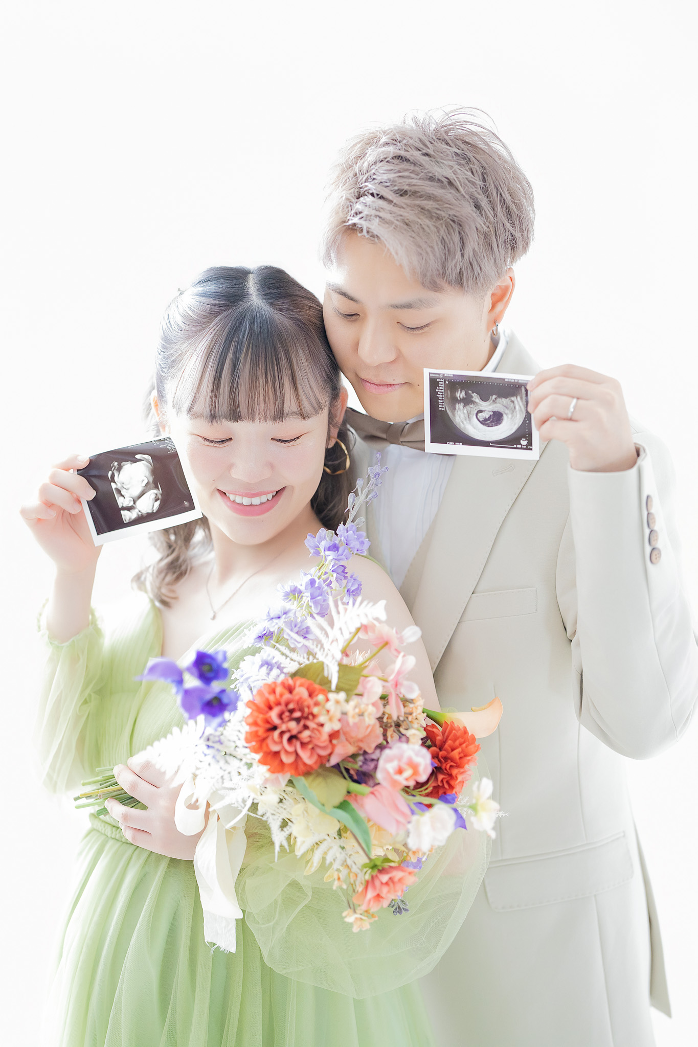 ブーケとエコー写真を手に、寄り添って笑顔を見せるご夫婦