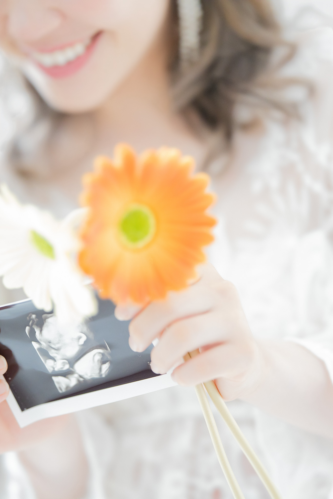 ガーベラとともにエコー写真を手にする様子の寄り