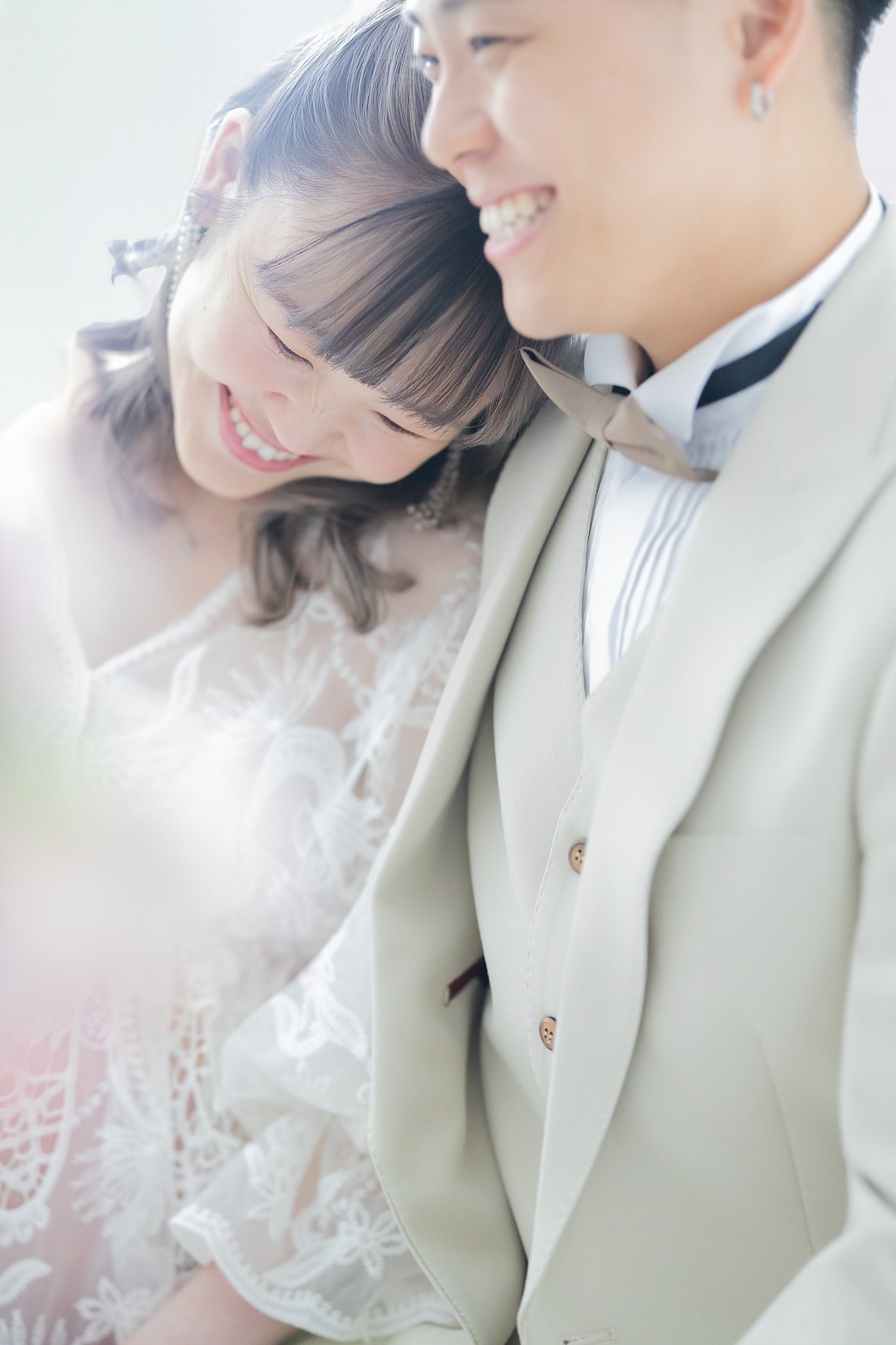 やわらかな逆光の中、寄り添って笑い合うご夫婦