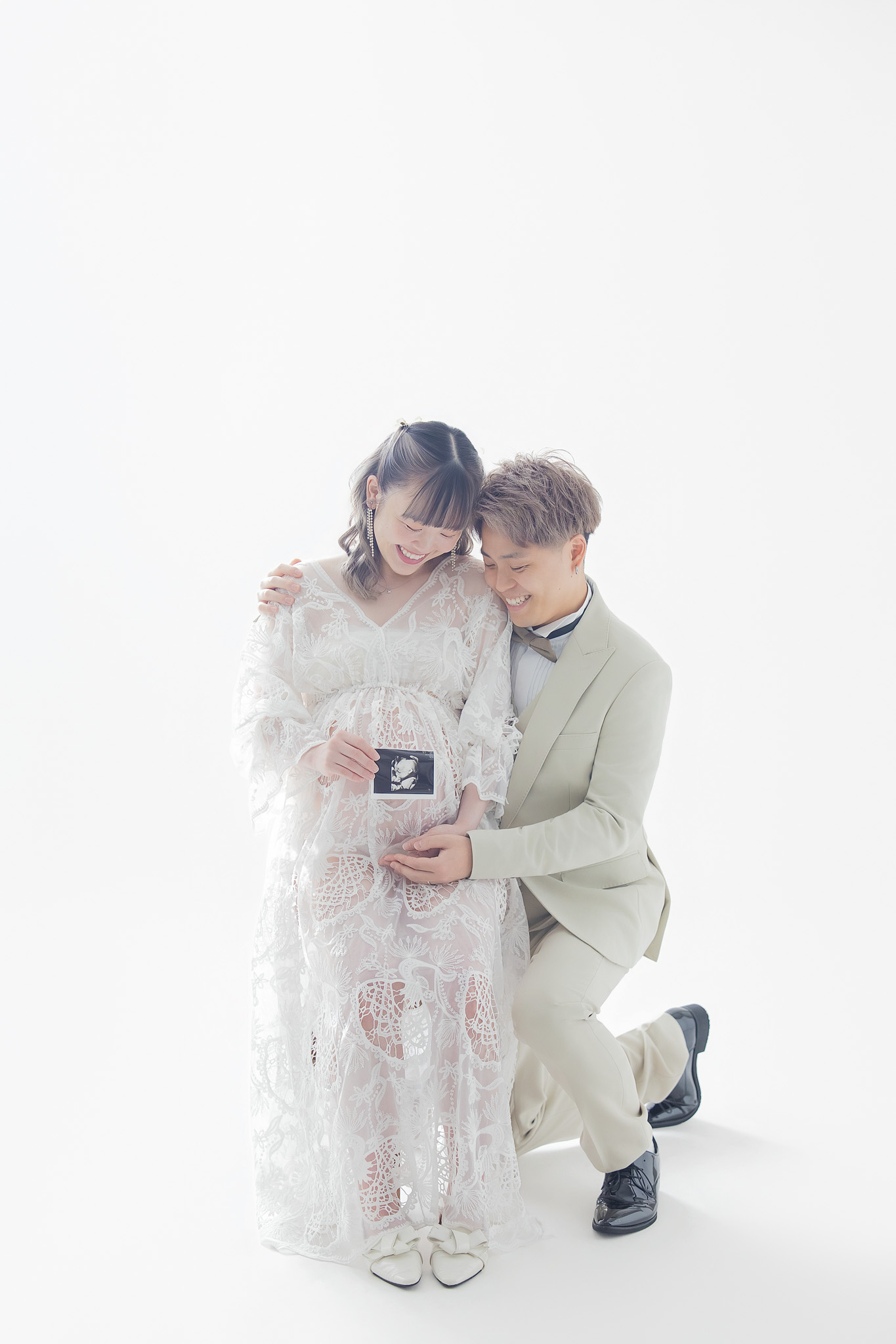 エコー写真を手に、お腹に寄り添うご夫婦