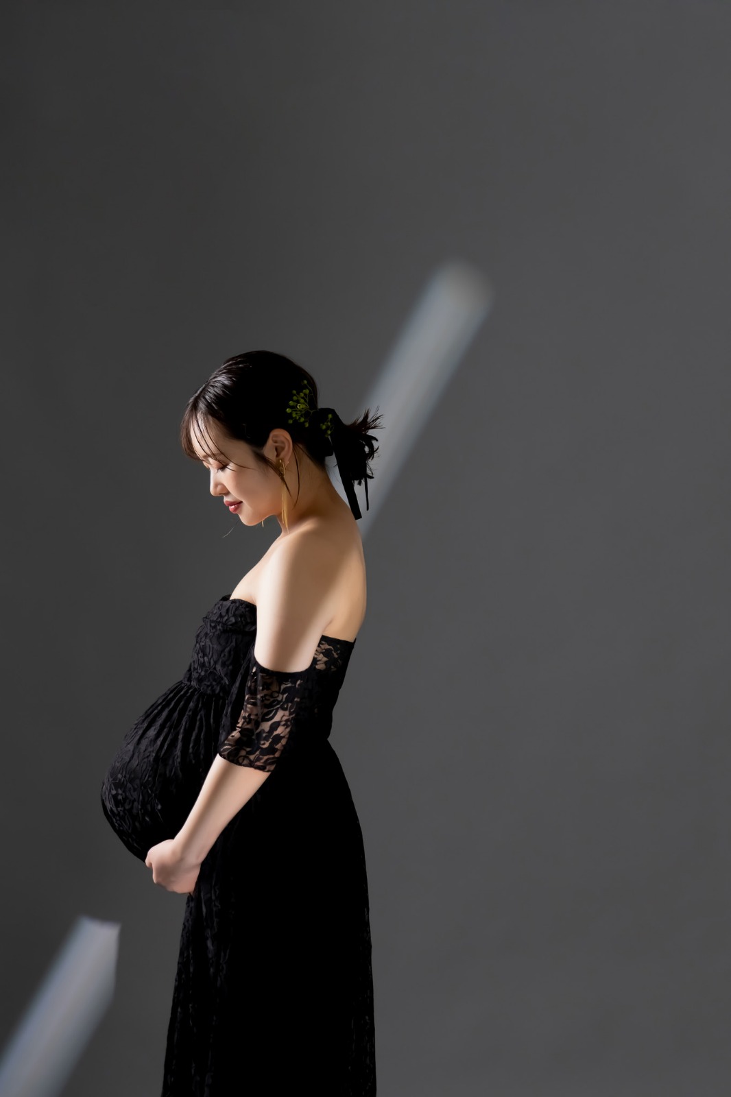 黒いドレス、お腹に手を添えた横顔