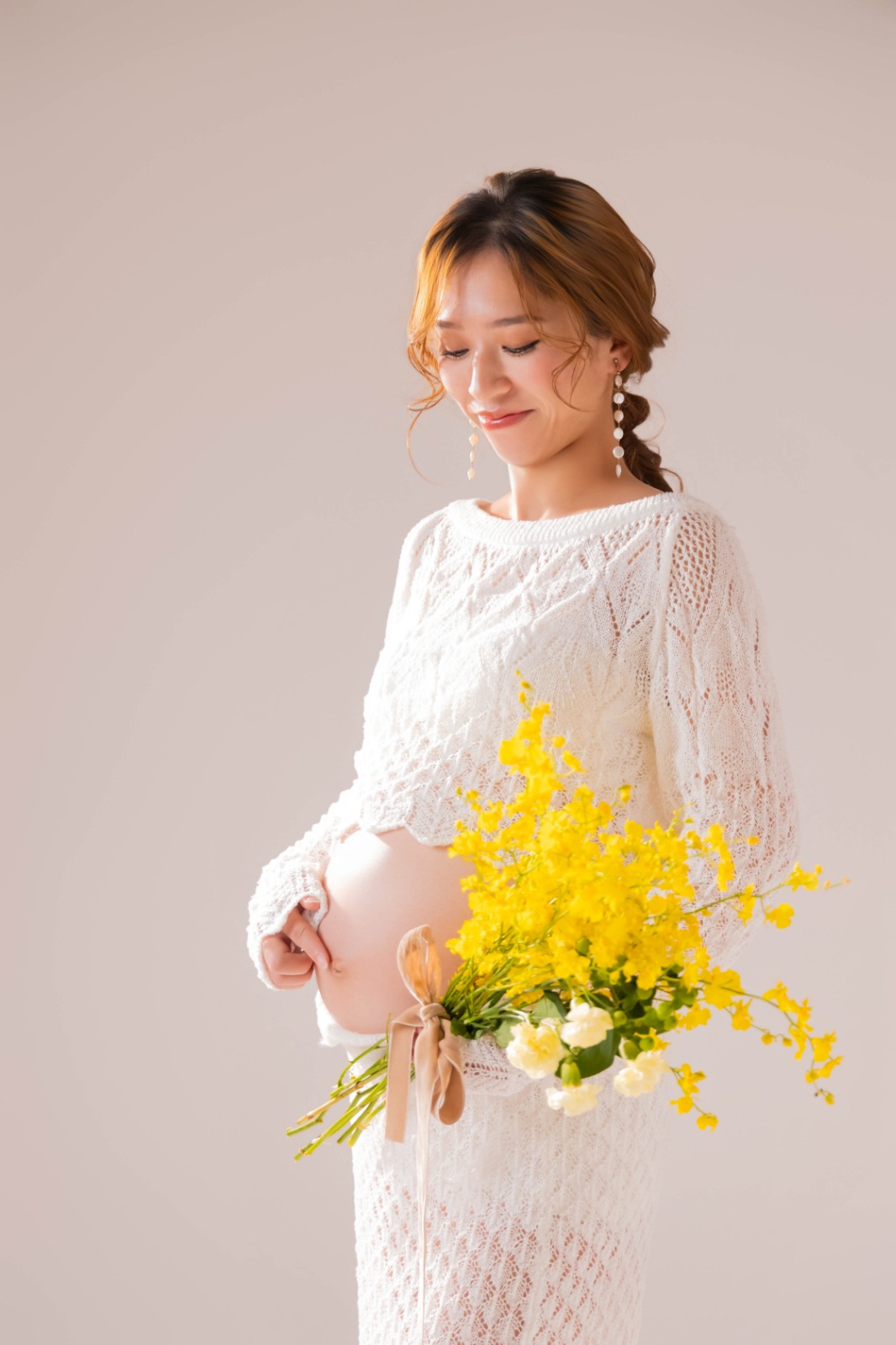 ミモザの花束を抱えた、レースドレスの立ち姿