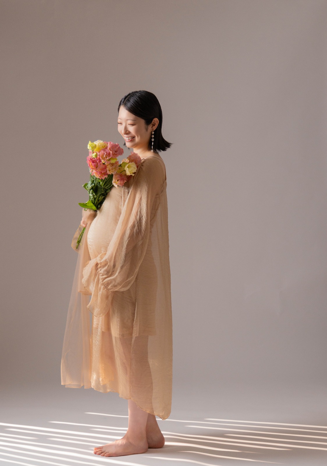 花を手にした、素足のシフォンドレス