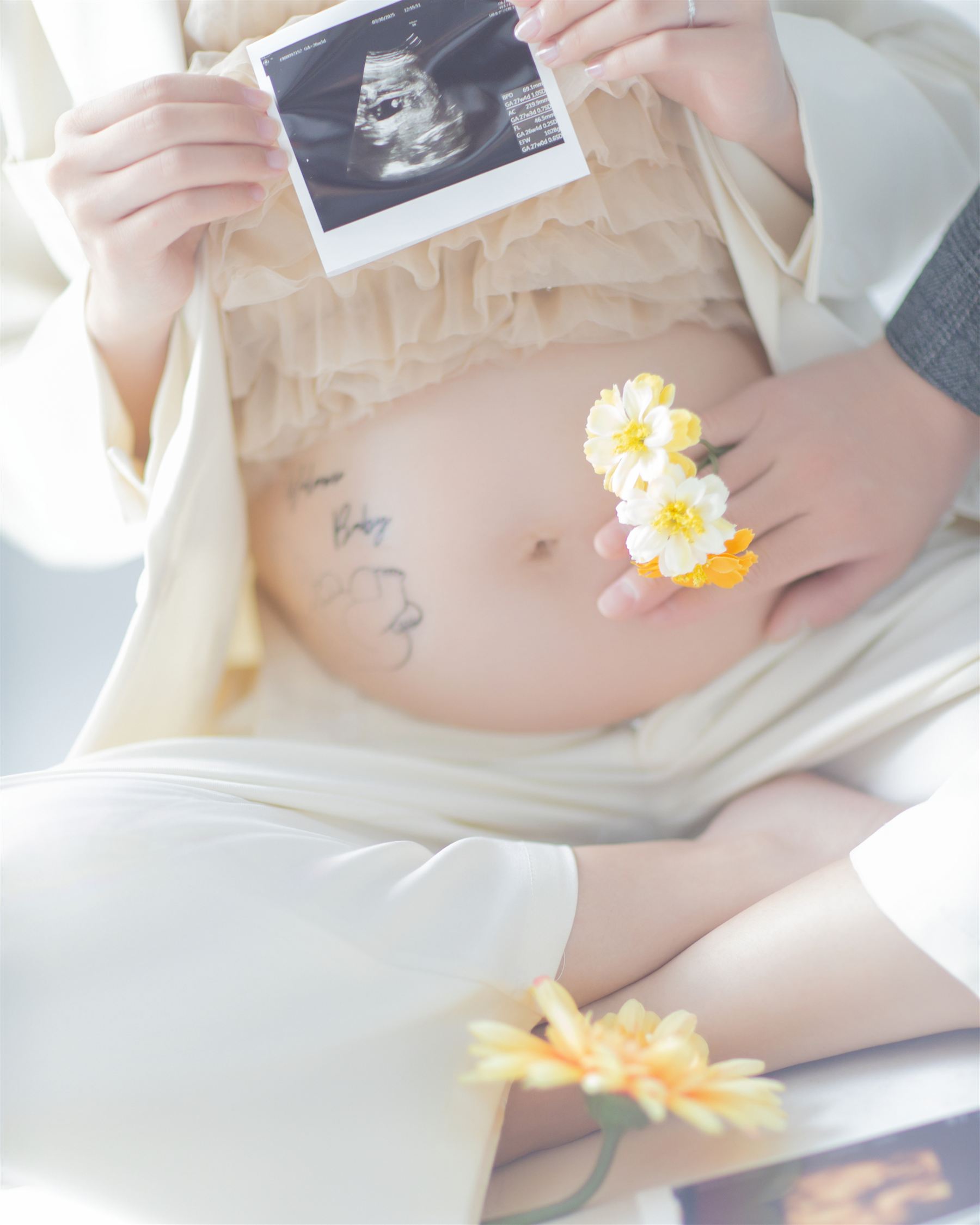 エコー写真と花を添えた、お腹のクローズアップ