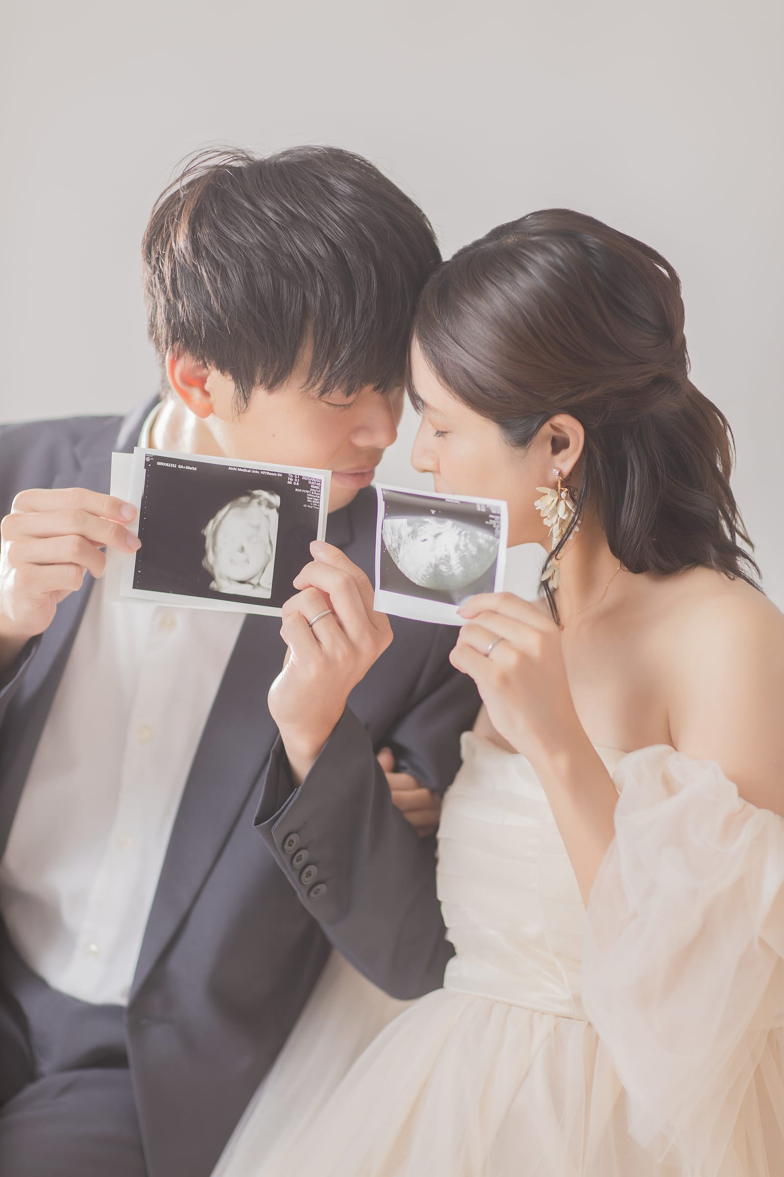 エコー写真を並べて顔を寄せ合うご夫婦